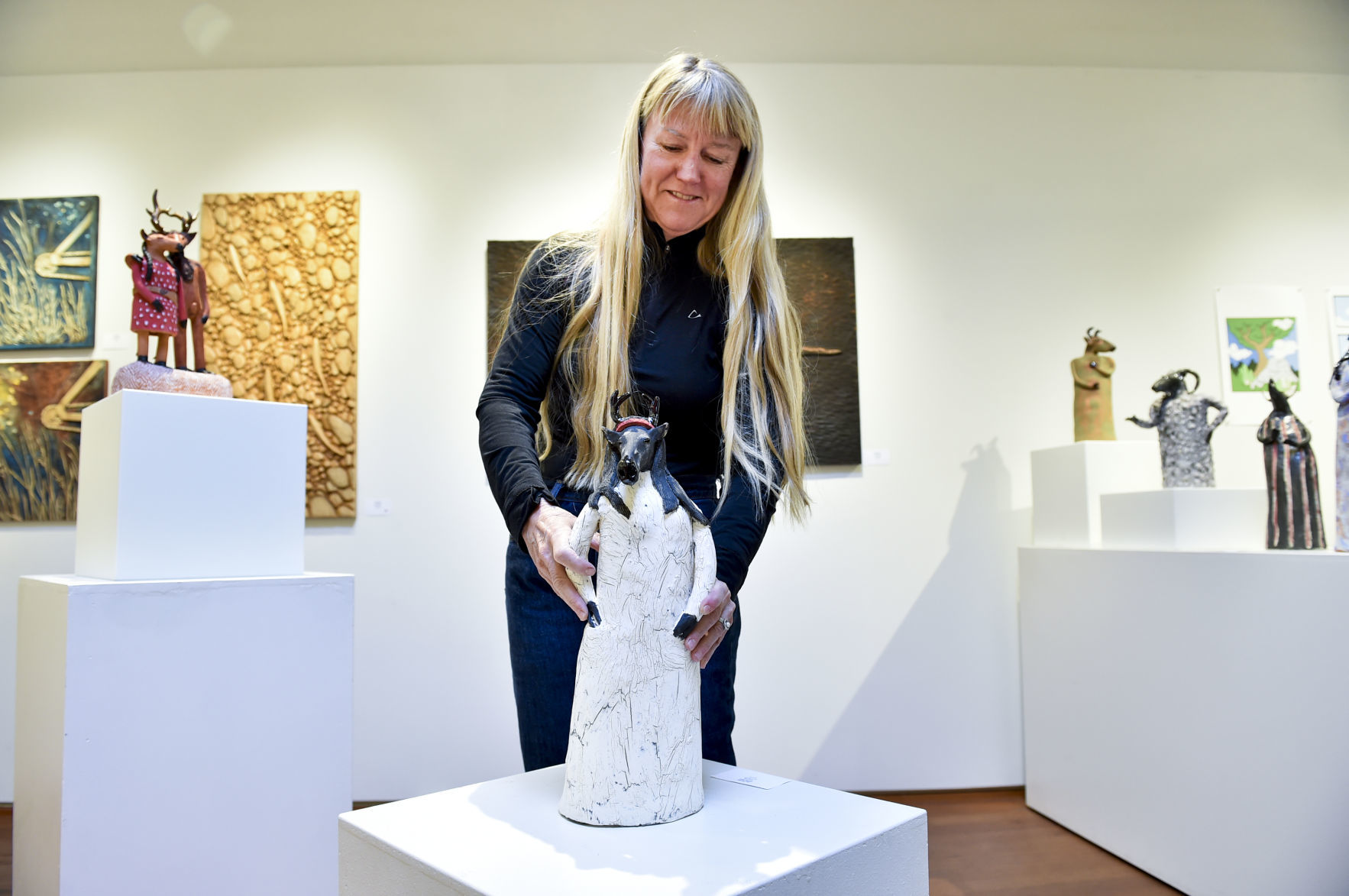 Betsey Hurd positions one of her works at 1+1=1 Gallery